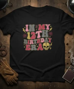 Retro "In My 12th Birthday Era" text design with skull and lightning bolts graphic on a black t-shirt