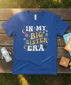 Retro groovy t-shirt with "In My Big Sister Era" text, stars, moons, and flowers in pastel colors