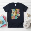 In My Big Sister Era text design with colorful retro lettering and floral accents on a navy t-shirt