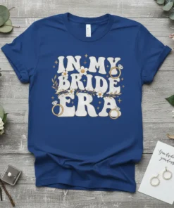 In My Bride Era t-shirt design with retro font, engagement rings, and floral accents in white and gold