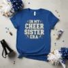 In My Cheer Sister Era text design with glitter accents and lightning bolts on a royal blue t-shirt
