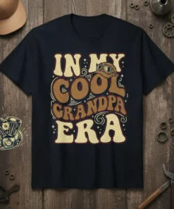 Retro "In My Cool Grandpa Era" text design with vintage goggles graphic on a navy t-shirt