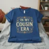 Blue t-shirt with gold text "In My Cousin Era" in a vintage, celestial design
