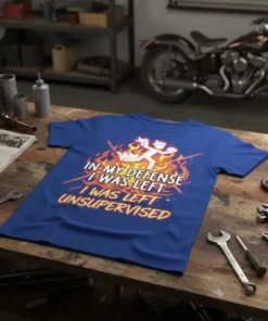 Blue t-shirt with bold white and yellow text: "IN MY DEFENSE I WAS LEFT I WAS LEFT UNSUPERVISED" surrounded by