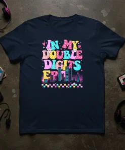In My Double Digits Era text in colorful retro font with city skyline graphic on a navy blue t-shirt