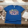 In My Engaged Era text with floral and heart graphics on a blue t-shirt, perfect for brides to be