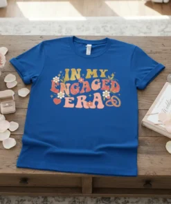 In My Engaged Era text with floral and heart graphics on a blue t-shirt, perfect for brides to be