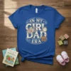 In My Girl Dad Era text with floral graphics and a briefcase on a blue t-shirt