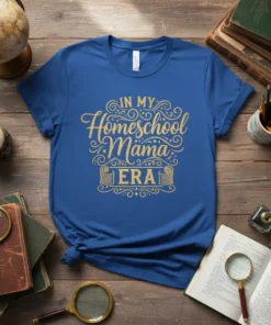 Blue t-shirt with gold "IN MY Homeschool Mama ERA" text in decorative font, featuring scrollwork and a book graphic
