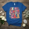 Retro style "In My Junior Bridesmaid Era" text design with colorful wavy font and floral accents on a blue t-shirt