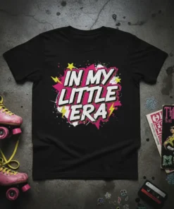 Black t-shirt with white and pink text "IN MY LITTLE ERA" in a bold, retro comic book style, surrounded by