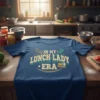 In My Lunch Lady Era text design with whisk and spatula graphics on a blue t-shirt