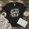 In My Nonnie Era text design with floral and star accents on a black t-shirt