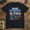 Black t-shirt with "IN MY PHLEBOTOMIST ERA" in neon blue, featuring graphics of a blood bag, syringe, colorful vials, and