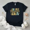 In My Pregnant Era maternity t-shirt with retro font and baby feet graphic