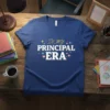 Blue t-shirt with white text "IN MY PRINCIPAL ERA" in a fun font, surrounded by colorful stars and hearts