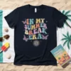 Retro graphic t-shirt with colorful text "In My Summer Break Era" and butterfly and sun designs