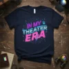 Navy t-shirt with neon pink and blue text reading "IN MY THEATER ERA" and graphic elements