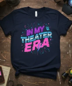Navy t-shirt with neon pink and blue text reading "IN MY THEATER ERA" and graphic elements