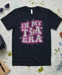 In My Tia Era text with pink butterflies on a black t-shirt, glittery font, and sparkling accents
