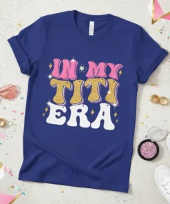 Retro groovy "In My Titi Era" text design with pink, gold glitter, and white lettering on a blue t-shirt