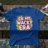 In My Wacky Era text design with retro graffiti, skulls, and safety pins on a blue t-shirt