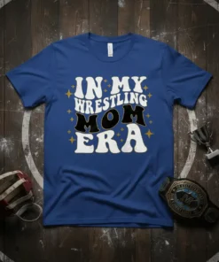 In My Wrestling Mom Era text design on a blue t-shirt, featuring retro wavy font and stars