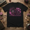 In October We Wear Pink text with a witchy design including spiderweb, bats, and crystal staffs, on a black t-shirt