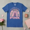 Blue t-shirt with "In October We Wear Pink" text, rainbow, roses, and pink ribbon graphic for breast cancer awareness