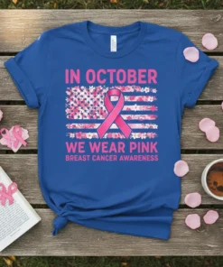 Blue t-shirt design with pink text "In October We Wear Pink Breast Cancer Awareness" and a floral American flag with