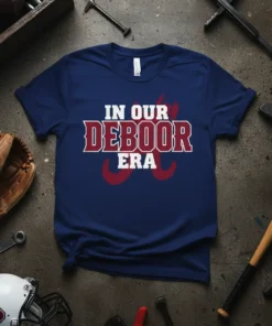 Navy t-shirt with "IN OUR DEBOOR ERA" text in distressed white and maroon, featuring crimson wave graphics