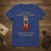 T-shirt with gold text "In These Difficult Times Some Cuts May Be Necessary" and an illustration of a guillotine with