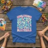 Retro graphic t-shirt with the text "INCLUSION MATTERS" in bold, colorful lettering and a pattern of geometric shapes and butterflies