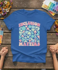 Retro graphic t-shirt with the text "INCLUSION MATTERS" in bold, colorful lettering and a pattern of geometric shapes and butterflies