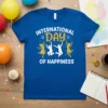 International Day of Happiness t-shirt design with white and gold text and leaping figures celebrating joy