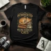 Black t-shirt with "INTROVERTED BUT WILLING TO DISCUSS CATS" text and an illustration of a sleeping cat on books
