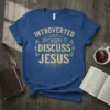 Christian t-shirt with "Introverted But Willing To Discuss Jesus" text in ornate golden font on a blue shirt
