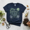 Navy blue t-shirt with the text "INTROVERTED BUT WILLING TO DISCUSS PLANTS." in green, surrounded by vine graphics