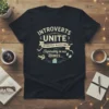 Black t-shirt with "INTROVERTS UNITE SEPARATELY IN OUR OWN SEPARATELY IN OUR HOMES..." text and graphics of books and headphones