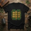 Black t-shirt with "IRISH AF IRISH AF IRISH AF" repeated in gold lettering, surrounded by shamrocks and Celtic knot designs