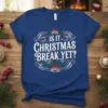 Is It Christmas Break Yet? text with festive bells, holly, and snowflakes graphic on a blue t-shirt