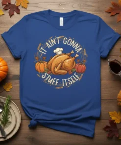 It Ain't Gonna Stuff Itself Thanksgiving turkey and pumpkin design on a blue t-shirt, featuring chef hat and fall leaves