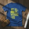Blue t-shirt with yellow distressed text reading "IT IS WHAT IS" in bold block letters