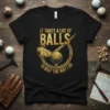 Black t-shirt with gold text "IT TAKES A LOT OF BALLS TO GOLF THE WAY I DO" featuring golf club