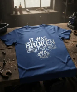 It Was Broken When I Got Here quote on a blue t-shirt, featuring distressed text and a gear graphic