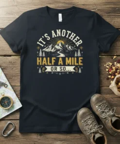 It's Another Half A Mile Or So... text design with mountains and sun graphic on a black t-shirt