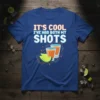 Blue t-shirt with white and orange text "IT'S COOL I'VE HAD BOTH MY SHOTS" and illustration of two shot glasses