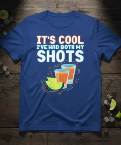 Blue t-shirt with white and orange text "IT'S COOL I'VE HAD BOTH MY SHOTS" and illustration of two shot glasses