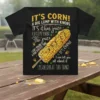 T-shirt featuring the quote "IT'S CORN! A BIG LUMP WITH KNOBS IT has juice" with a graphic of corn on