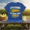 Blue t-shirt with "It's Corn! It Has The Juice" text and an illustration of a corn cob